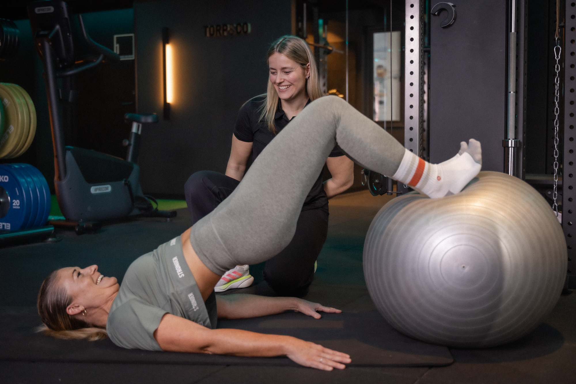 Kvinne utfører glute bridge på stabilitetsball hos Torp&Co
