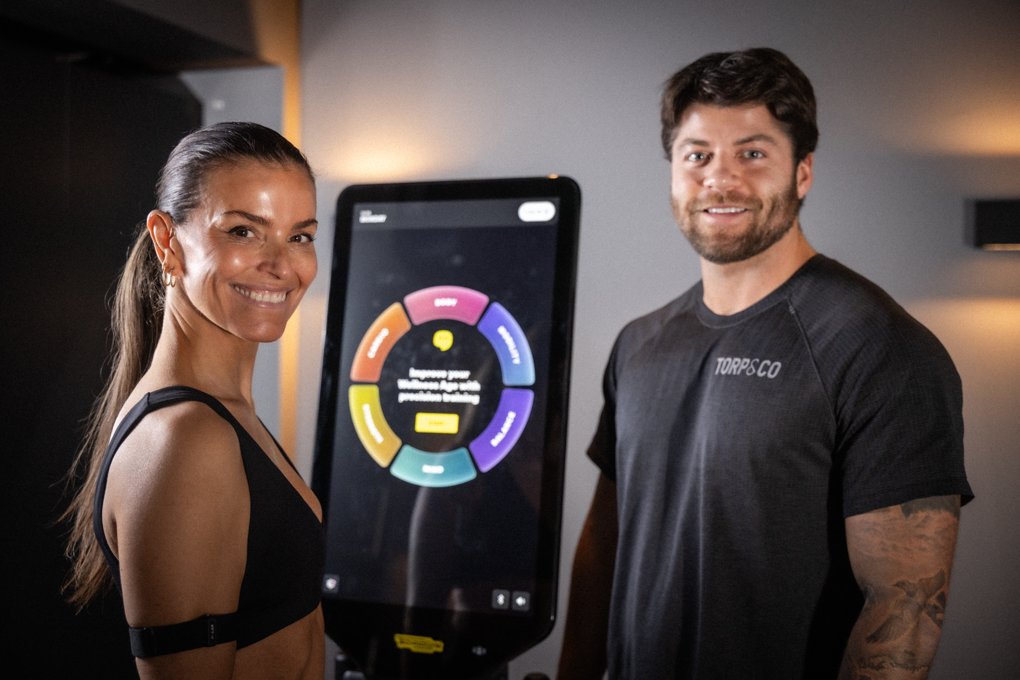Torp&Co-trener og klient ved Technogym-skjerm som viser Wellness Age