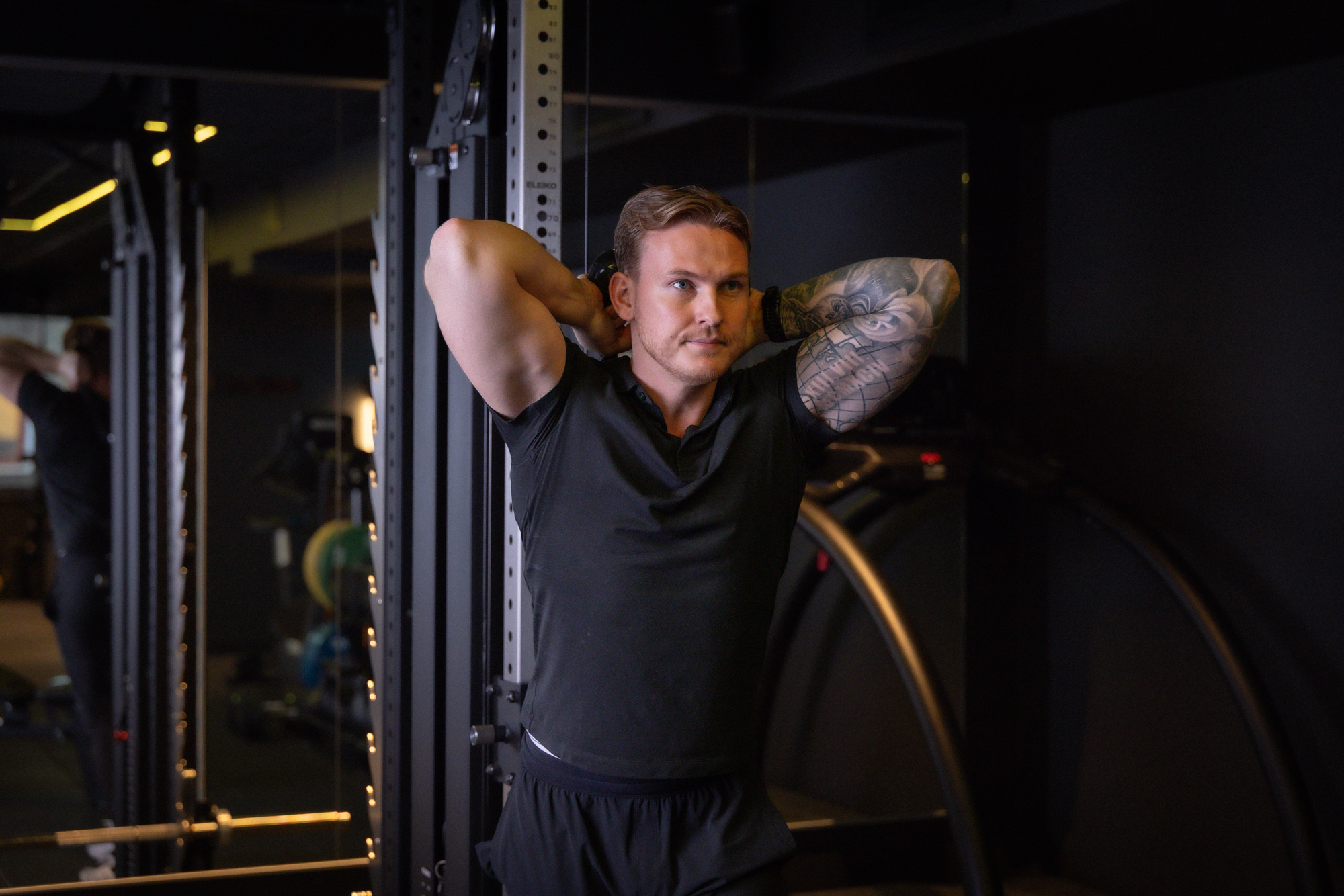 Mann med tatovering utfører kabeløvelse hos Torp&Co